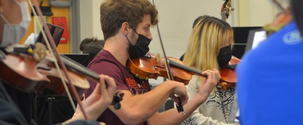 Henry Smith plays the violin at a Marshall choir concert